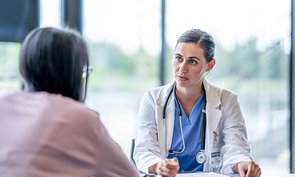 Eine junge Ärztin spricht mit einer Patientin.