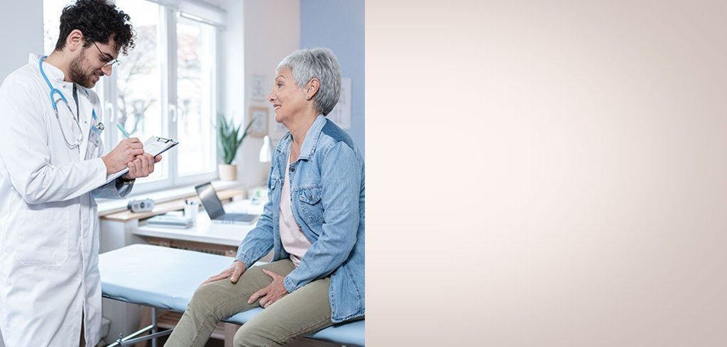 Ein internationaler Arzt spricht mit seiner Patientin in seiner eigenen Praxis.