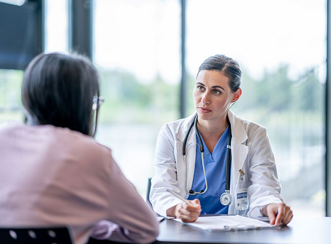 Eine junge Ärztin spricht mit einer Patientin.