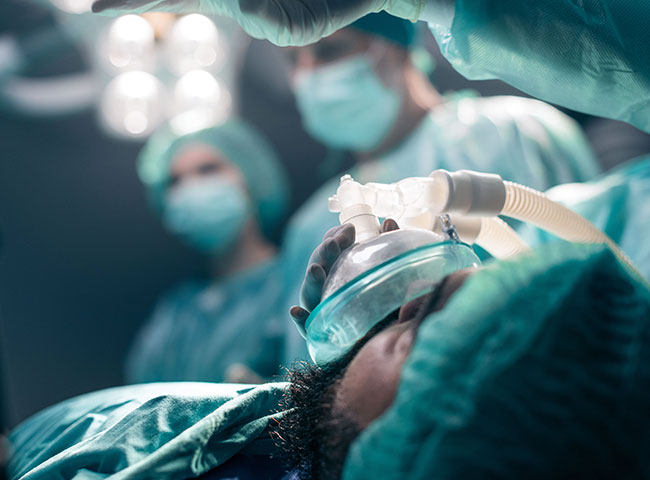 Ein Patient mit Sauerstoffmaske auf einem Krankenhausbett